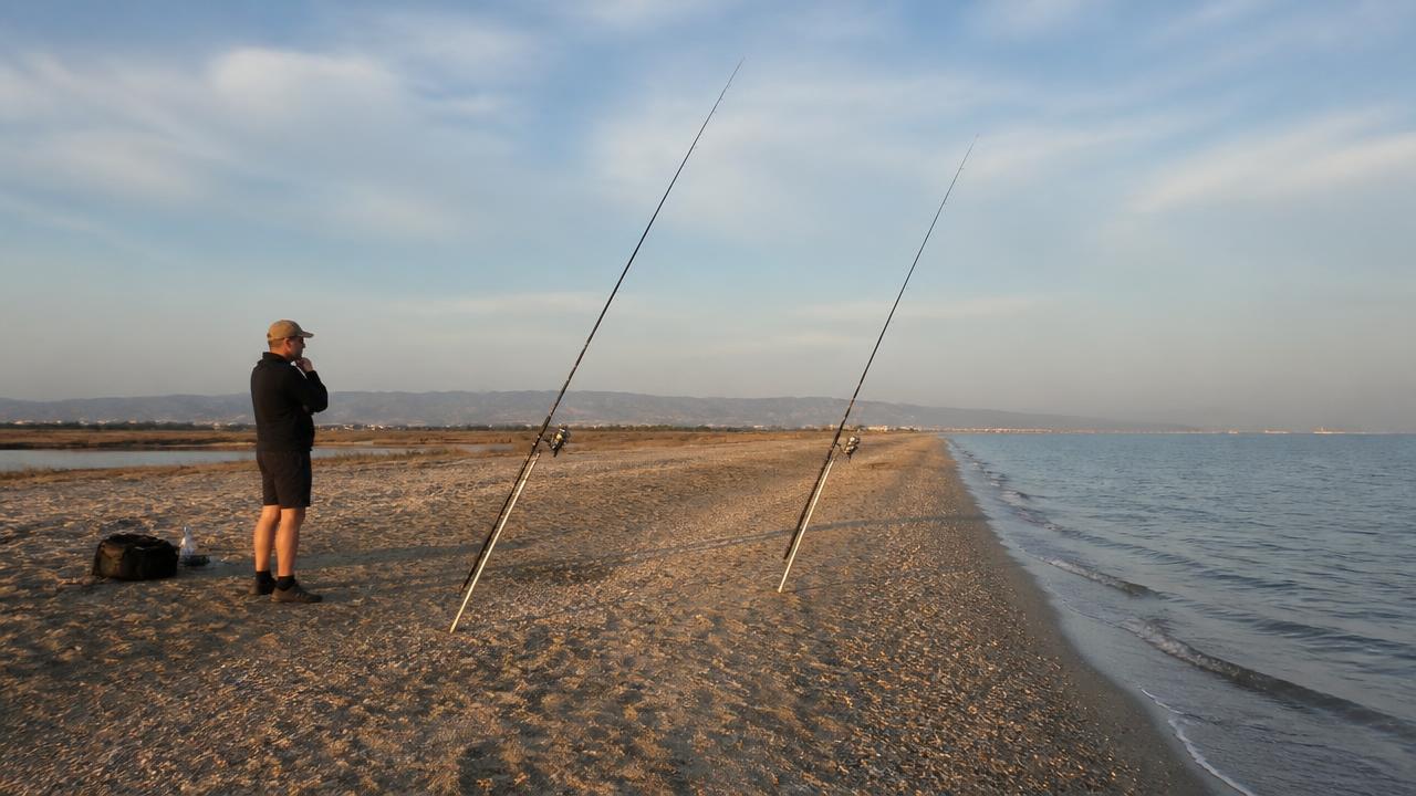 Surfcasting rods set up on tripods along the sandy shoreline of Lady’s Mile, Limassol, Cyprus